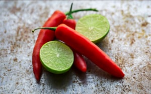 three red chili peppers with lime halves