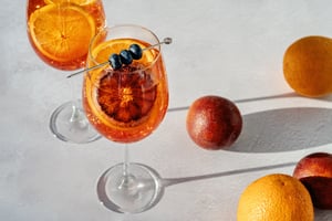 Cocktail and fruit on light background